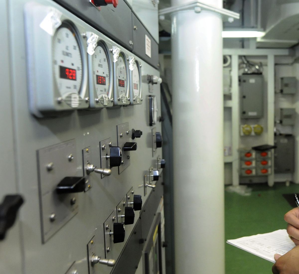 Tablero de distribución eléctrica con medidores y seccionadores en una sala de máquinas
